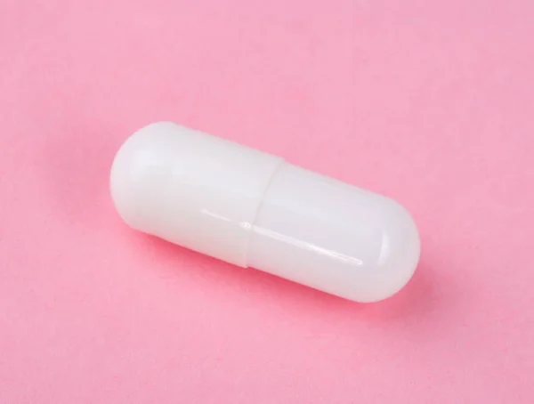 Weiße Pille auf rosa Hintergrund — Stockfoto