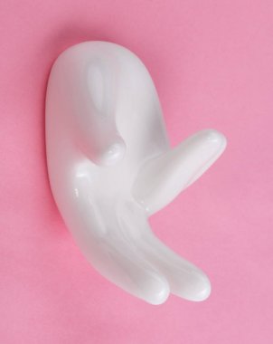 Pembe arka planda el şekli olan seramik standı