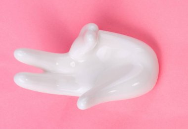 Pembe arka planda el şekli olan seramik standı