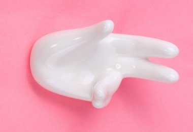 Pembe arka planda el şekli olan seramik standı