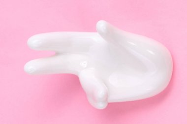 Pembe arka planda el şekli olan seramik standı