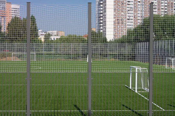 Güneşli bir günde çitin yanında futbol sahası — Stok fotoğraf