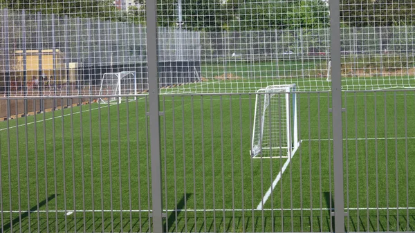 Fußballplatz in der Nähe von Zaun am sonnigen Tag — Stockfoto