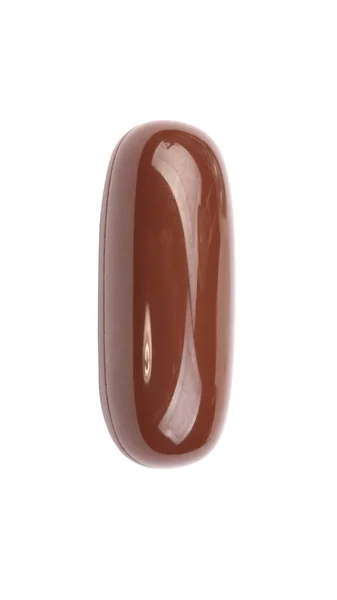 Uma pílula de gelatina marrom isolada em backgroung branco — Fotografia de Stock
