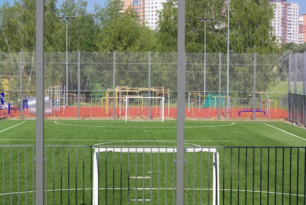 Güneşli bir günde çitin yanında futbol sahası — Stok fotoğraf