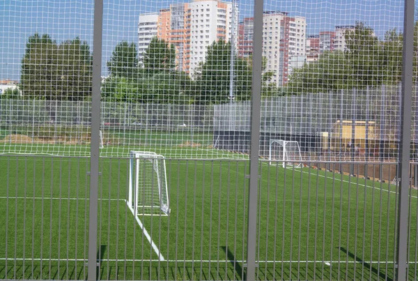 Campo de fútbol cerca de valla en el día día soleado —  Fotos de Stock