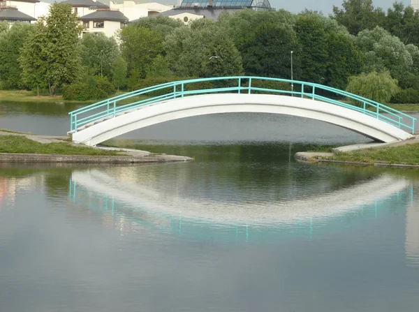 Мост через пруд в городском парке — стоковое фото