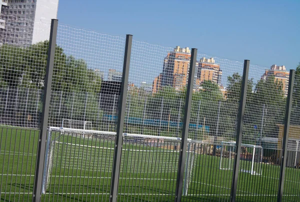 Campo de fútbol cerca de valla en el día día soleado —  Fotos de Stock
