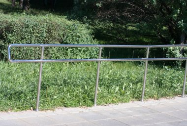 Güneşli yaz gününde parkta metal çitler