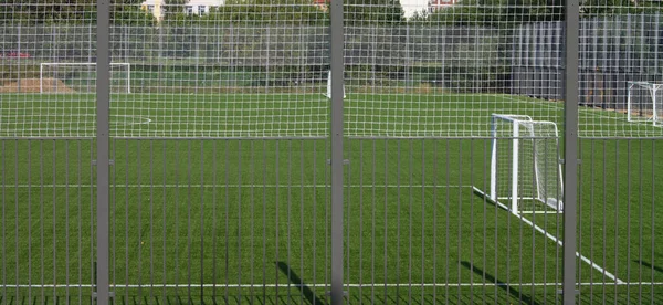 Fußballplatz in der Nähe von Zaun am sonnigen Tag — Stockfoto