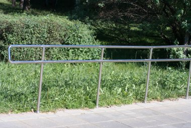 Güneşli yaz gününde parkta metal çitler
