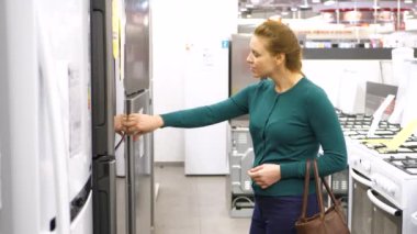 kadın bir buzdolabı deposunda satın alır. 4k Uhd.