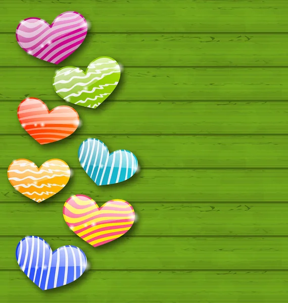 Multicolored striped hearts on green wooden texture for Valentin — Stock Photo, Image