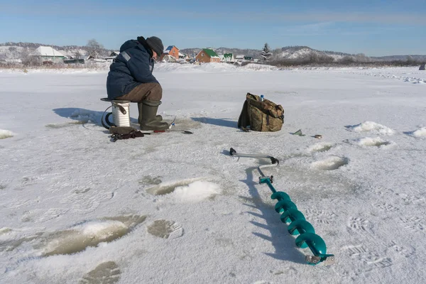 Pêcheur d'hiver sur la glace de la rivière — Photo