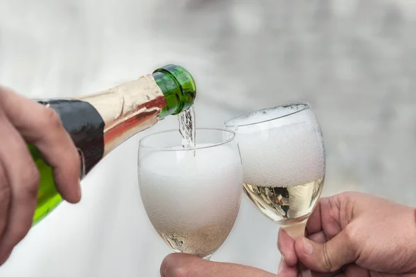 Wine is poured from a bottle into glasses — Stock Photo, Image