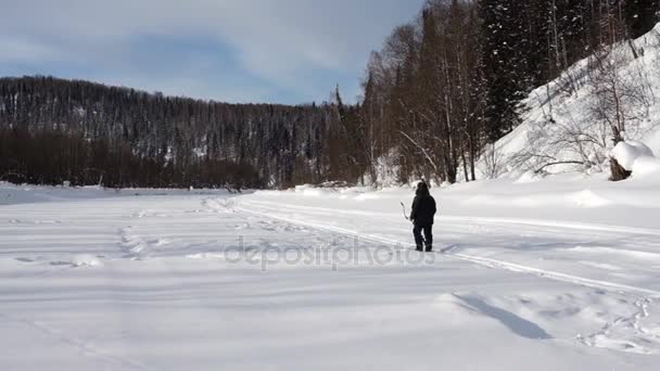 Рыбак на реке сверлит лёд — стоковое видео