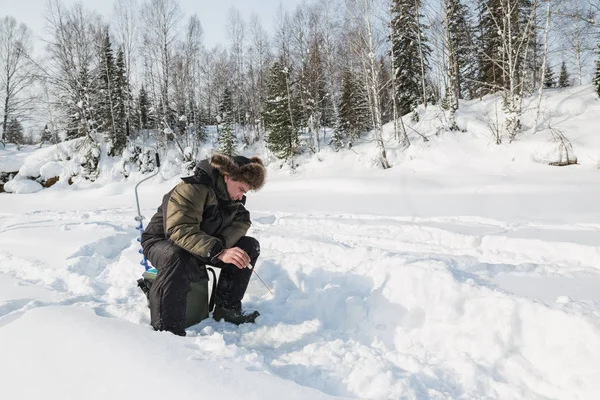 Il pescatore prende il pesce sul fiume nell'inverno — Foto Stock