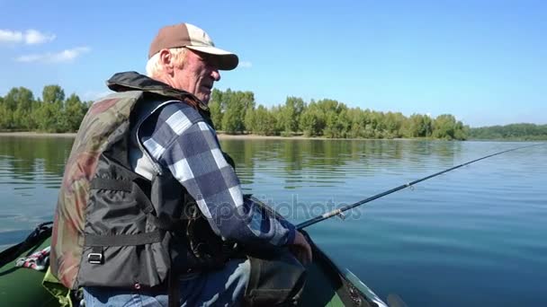 En fiskare i en båt är fiske — Stockvideo