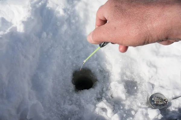 A fisherman's hand holding a winter fishing ro — Stock Photo, Image