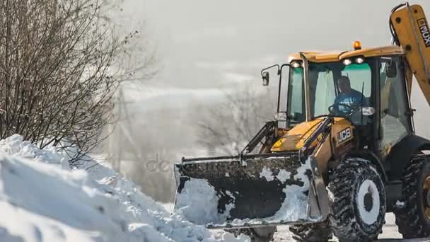 El hombre en el tractor despeja el camino de la nieve recién caída — Vídeos de Stock
