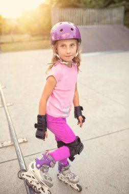 Güneşli bir parkta paten üzerinde genç