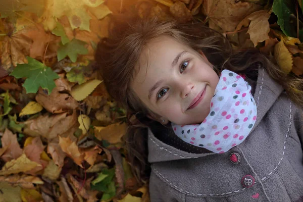 Young girl lying in leaves — Stock Photo, Image