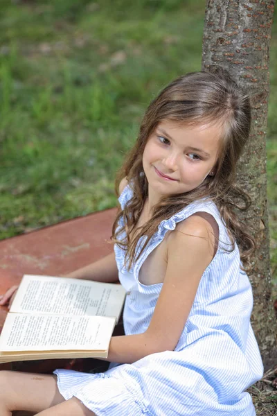 Junges Mädchen liest draußen ein Buch — Stockfoto