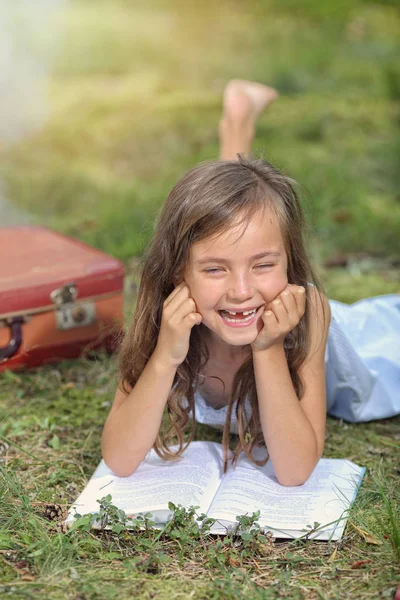 Lachendes junges Mädchen liest ein Buch — Stockfoto