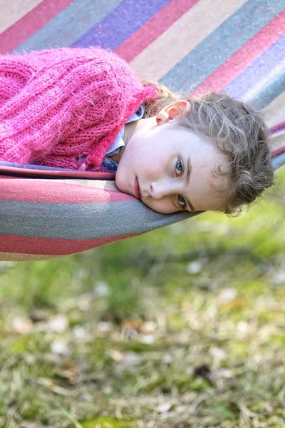 Молодая задумчивая девушка лежит в гамаке — стоковое фото