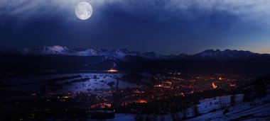 Ay ışığı burie tarafından aydınlatılmış Zakopane şehir üzerinde sihirli gece görünümü