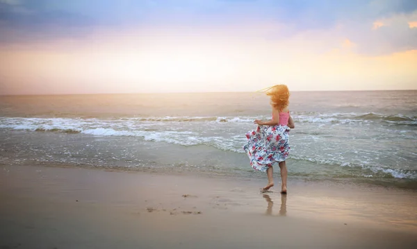 Bezstarostná holka tančí na pláži v šatech — Stock fotografie