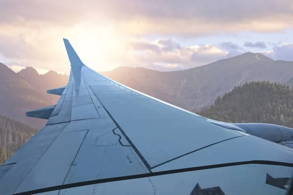 Vista desde la ventana del avión al atardecer y las montañas — Foto de Stock