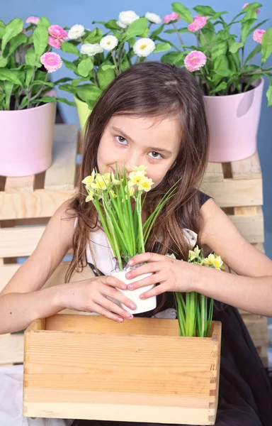 Menina jovem cheirando flores de primavera — Fotografia de Stock