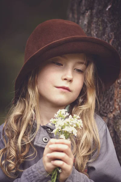 Young girl in a hat with a bouquet of flowers — Stock Photo, Image