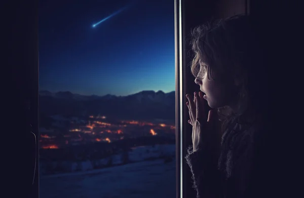 La fille regarde par la fenêtre l'étoile tombante — Photo