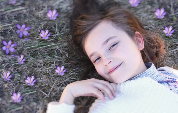 Mooi meisje ligt in Krokussen — Stockfoto