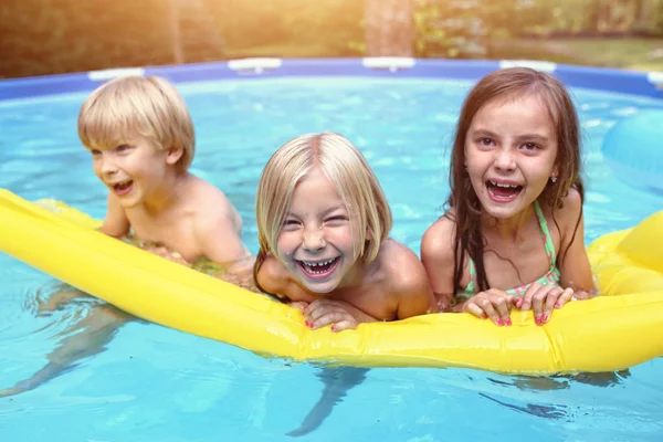 Divertidos jóvenes amigos en la piscina del jardín —  Fotos de Stock