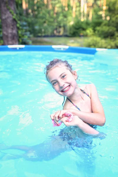 Mladá dívka v bazénu v teplý letní den — Stock fotografie