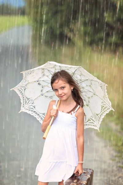 夏の冒険旅行 スーツケースと夏の雨の日に傘を持つ少女 — ストック写真