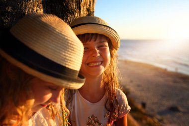 Arkadaşlar güneşli bir günde kumsalda eğlenir.