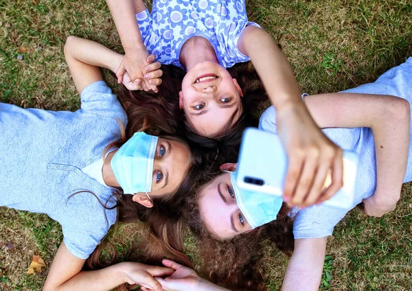 Jóvenes Amigos Acuestan Hierba Con Máscaras Tomar Una Foto —  Fotos de Stock