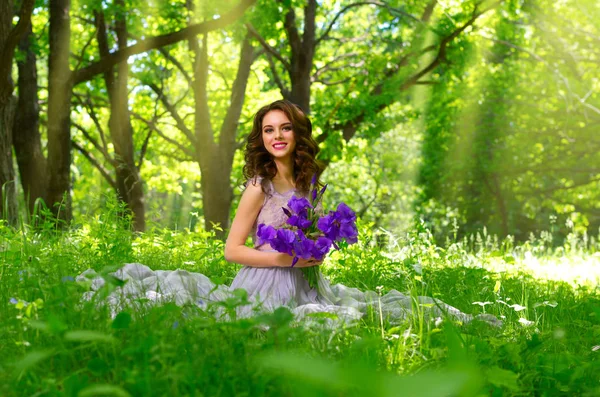 Mujer con flores en el bosque (con rayos de sol ver ) — Foto de Stock