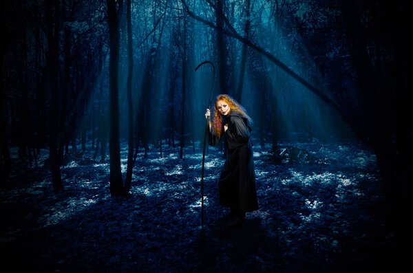 Scary witch in night forest