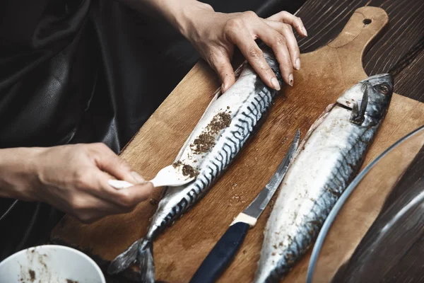 Жінка готує макрель рибу — стокове фото