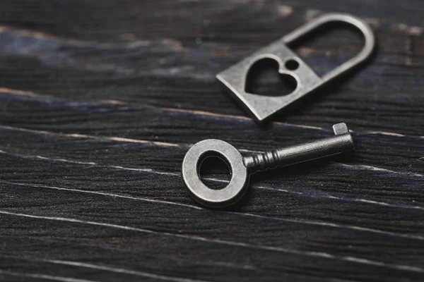 Vintage bronze lock and key on a wooden table — Stock Photo, Image