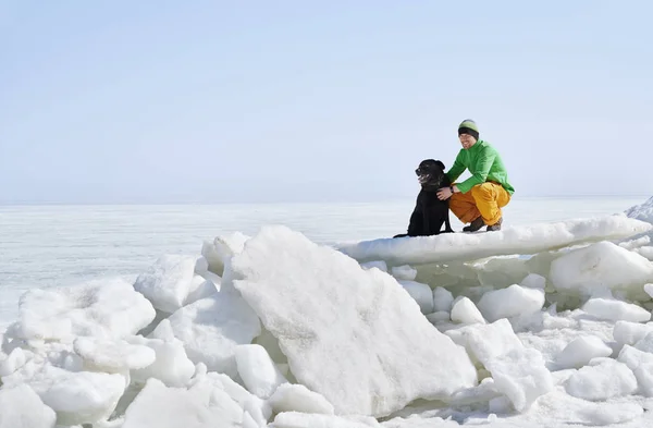 Fiatal felnőtt férfi szabadban kutyájával szórakozás téli földeken — Stock Fotó
