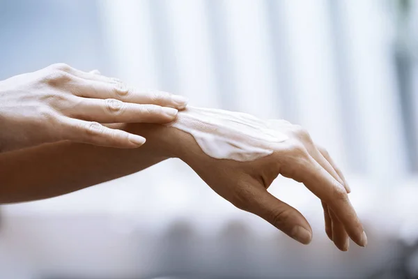Mulher Aplicando Creme Hidratante Nas Mãos — Fotografia de Stock