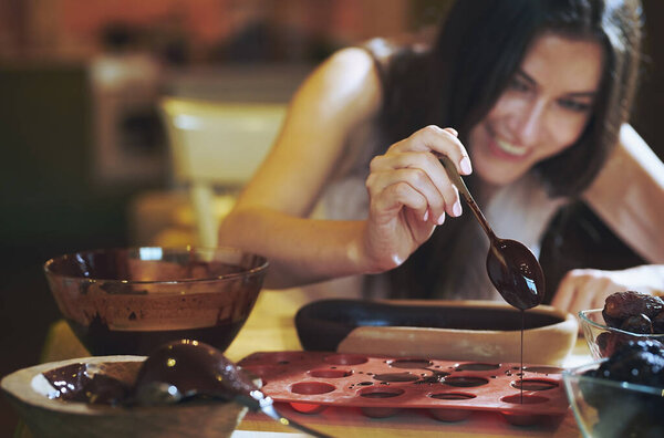 Staying at home woman preparing handmade vegetarian chocolate truffles