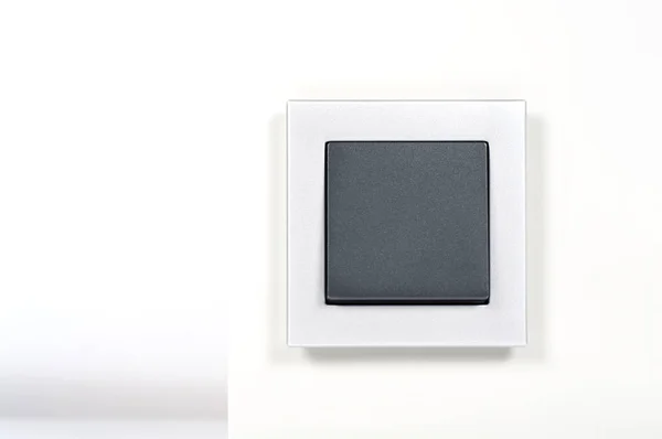Lichtschalter mit silbernem Glasrahmen an der Wand — Stockfoto