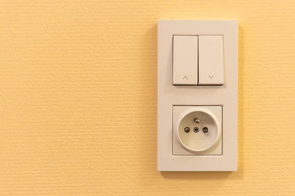 Light switch and socket in frame on the wall — Stock Photo, Image